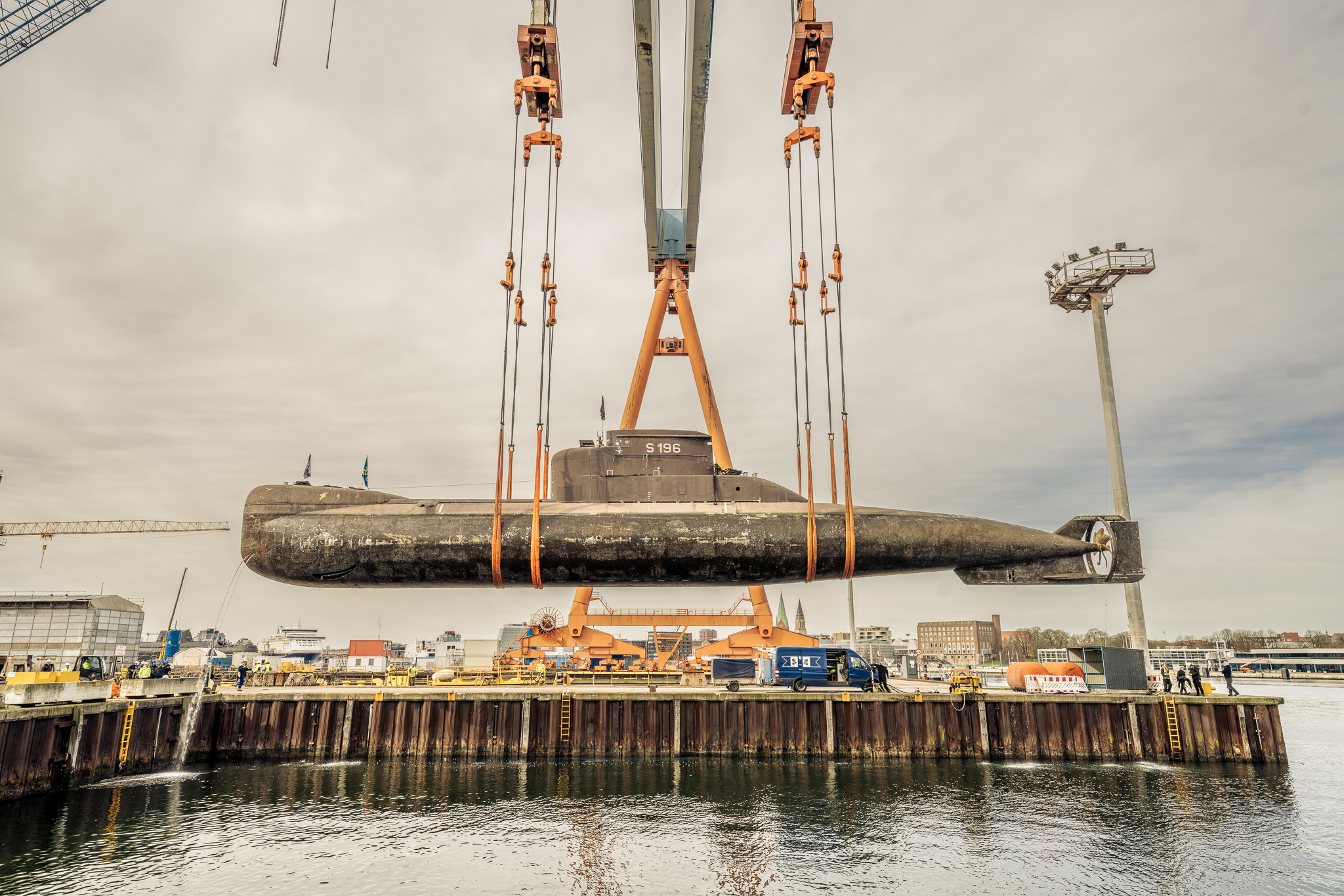 Stunden später wurde es von einem mächtigen 900-Tonnen-Portalkran im Stichhafen der German Naval Yards Kiel ins Trockendock gehoben.